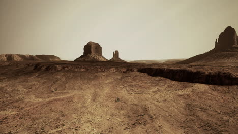expansive desert landscape showcasing rock formations under a hazy sky