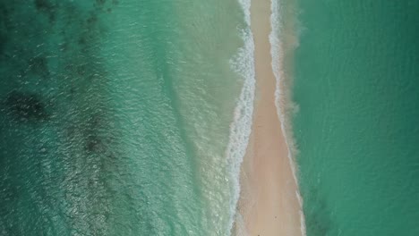 The-sandy-passage-at-cayo-de-agua,-los-roques,-turquoise-waters-embracing-the-shore,-aerial-view