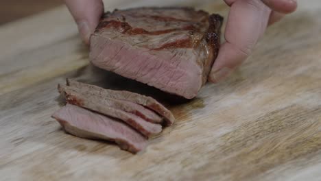 chef cutting beef steak into slices, for argentine barbecue with chimichurri and cafe de paris butter sauce