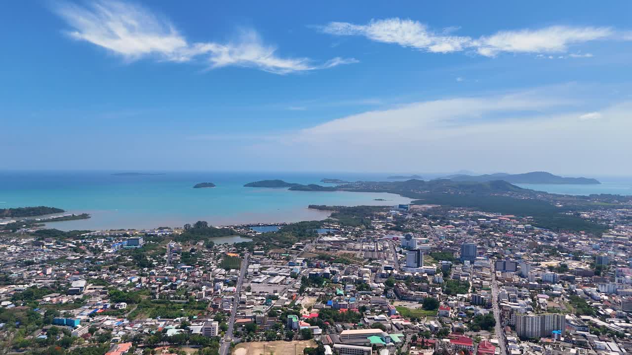 드론 영상은 푸켓의 활기찬 도시 풍경과 은 푸른 하늘 아래의 조용한 해안선을 포착하여 도시 개발과 자연의 아름다움을 강조합니다.