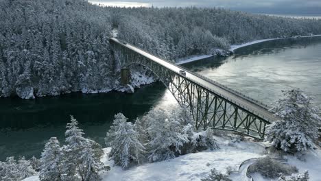 wide aerial view of deception pass bridge on whidbey island with snow covering the ground