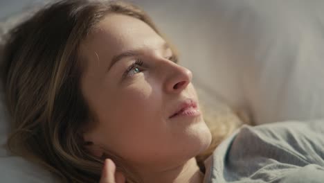 primer plano de una mujer caucásica disfrutando de la puesta de sol en la cama.