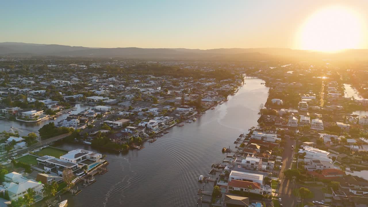 Aerial drone footage captures the serene Gold Coast skyline and Nerang River during a vibrant sunset