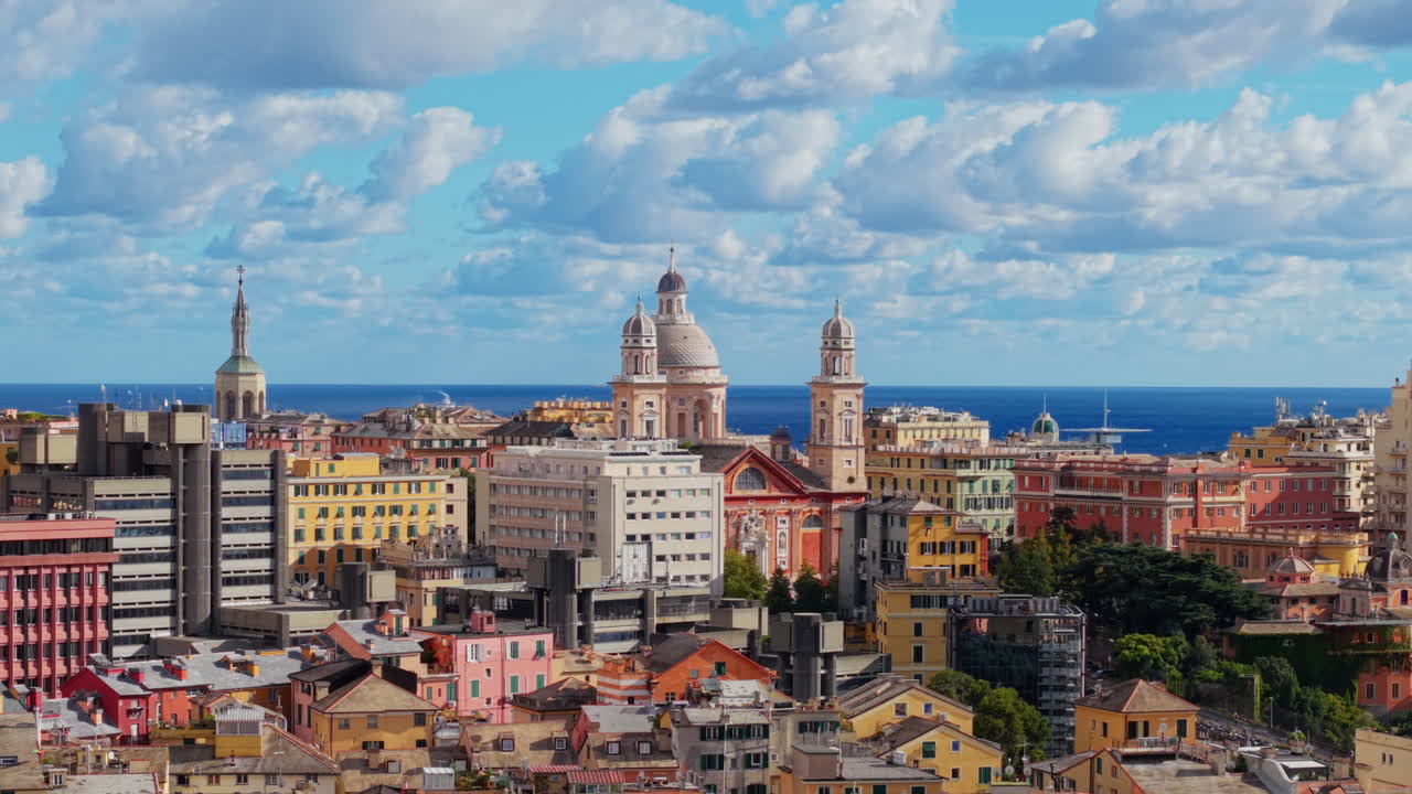 Drone panning left to right showing colorful Genoa skyline with churches and sea view