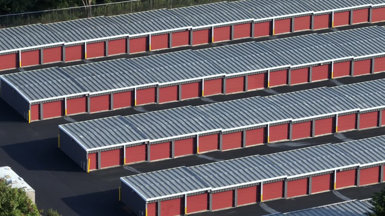 Row of orange colored Self Storage Unit Buildings or Warehouse Temporary Storage in summer. American suburb garage. Aerial wide shot. Virginia, USA