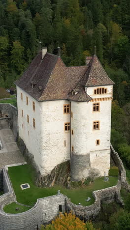 vertical, aerial: orbit drone shot of valangin castle during the day in canton of neuchatel, switzerland