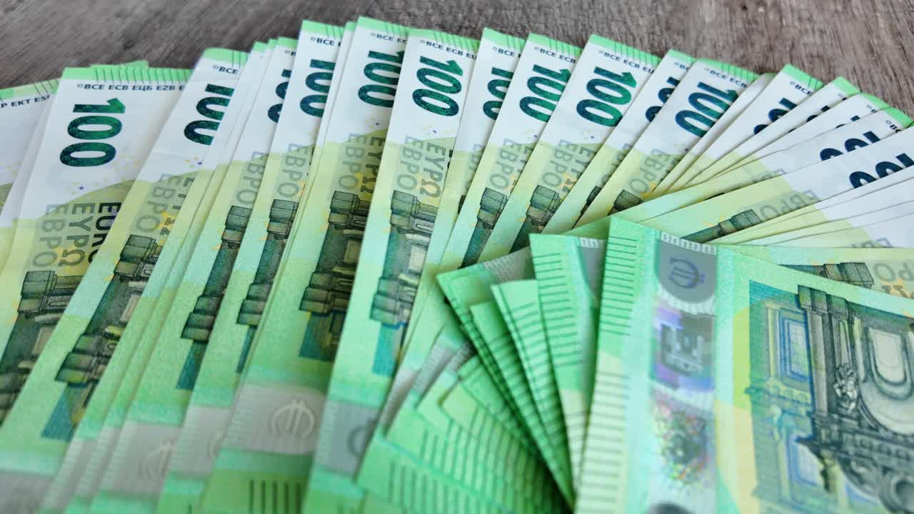 en vídeo a cámara lenta, los billetes de euro desplegados se extienden sobre la mesa
