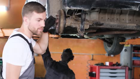 african american mechanic works on a laptop to diagnose a car engine an african american auto mechanic in overalls and gloves works on a laptop to diagnose a car engine in a professional workshop ensuring efficient vehicle maintenance