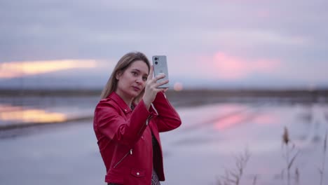 woman using phone outdoors at sunset