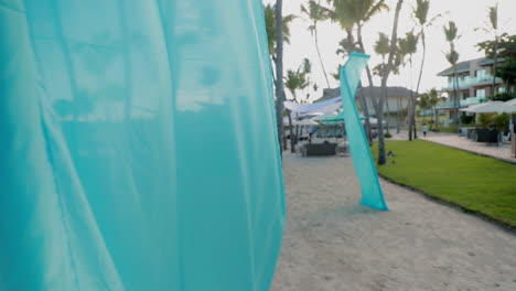 Slow-motion-parallax-shot-of-beach-with-blowing-fabric-in-the-foreground