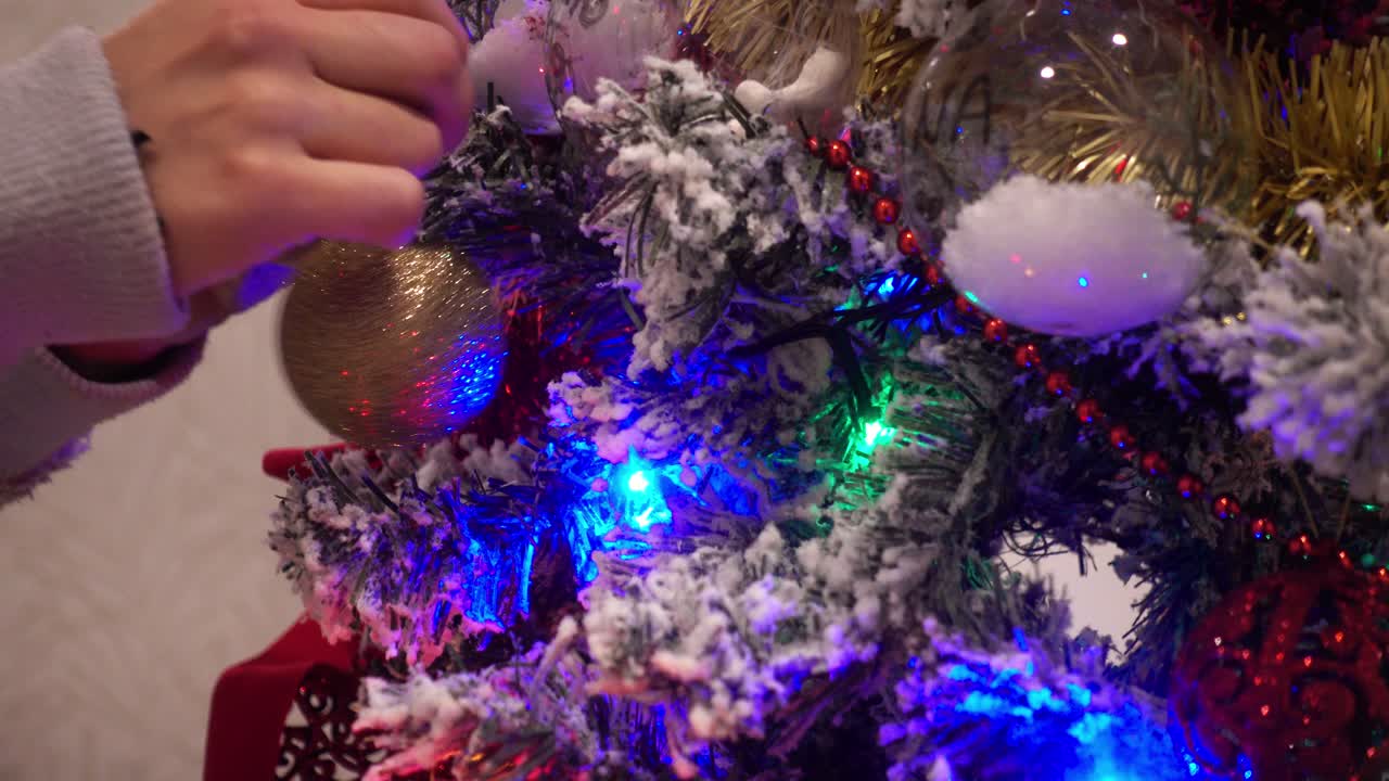 las manos de la mujer decorando el árbol de chritmas