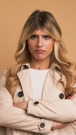Disappointed transgender woman nodding head against beige background
