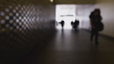 Toma-Desenfocada-De-Personas-Anónimas-Caminando-Por-El-Paso-Subterráneo-De-La-Ciudad.