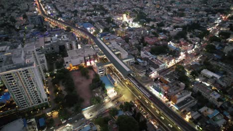 El-Metro-De-La-Ciudad-Se-Detiene-En-La-Estación-De-Metro,-Las-Calles-De-Tráfico-Y-Los-Edificios-De-Apartamentos,-Como-Se-Ve-En-Esta-Vista-Aérea-Vespertina-Del-Ajetreado-Barrio-De-Señales-Vadapalani-De-La-Ciudad-De-Chennai