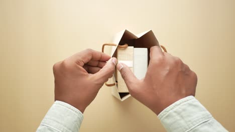 man opening a gift bag with a present