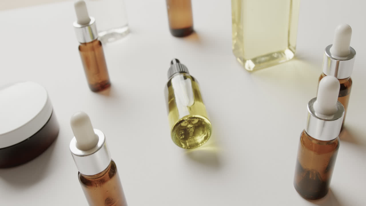 Close up of cream tub and glass bottles with copy space on white background
