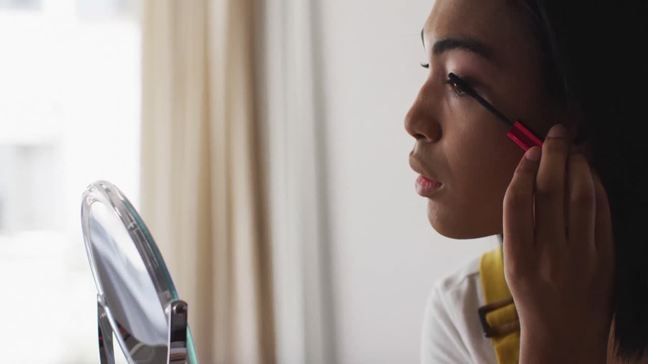 vlogger de género fluido de raza mixta grabando un vlog de maquillaje en casa