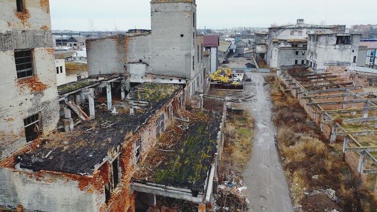 Vecchia fabbrica distrutta. Il tetto e le pareti di edifici industriali cosparsi di detriti. Vista aerea.