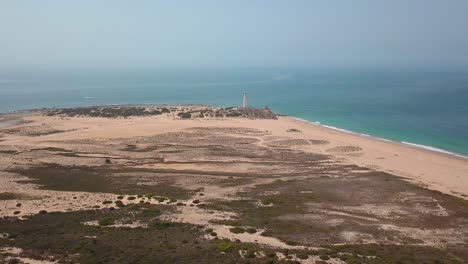 vista lejana del faro de cabo trafalgar construido en un promontorio histórico en la costa del océano atlántico en cádiz, españa
