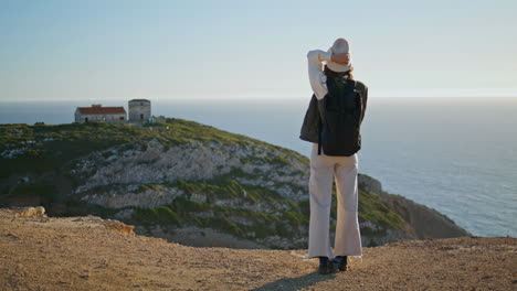 viajero de montaña hablando por teléfono en la vista tranquila del océano. niña de senderismo caminando por el acantilado