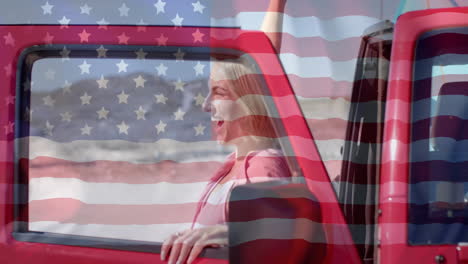 animation of flag of usa over happy caucasian woman by car on beach