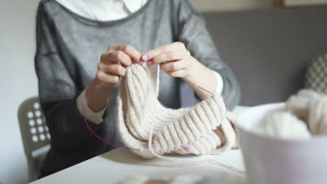 Close-up-of-female-hands-knitting-needles-wool-clothes.-Woman-hobby