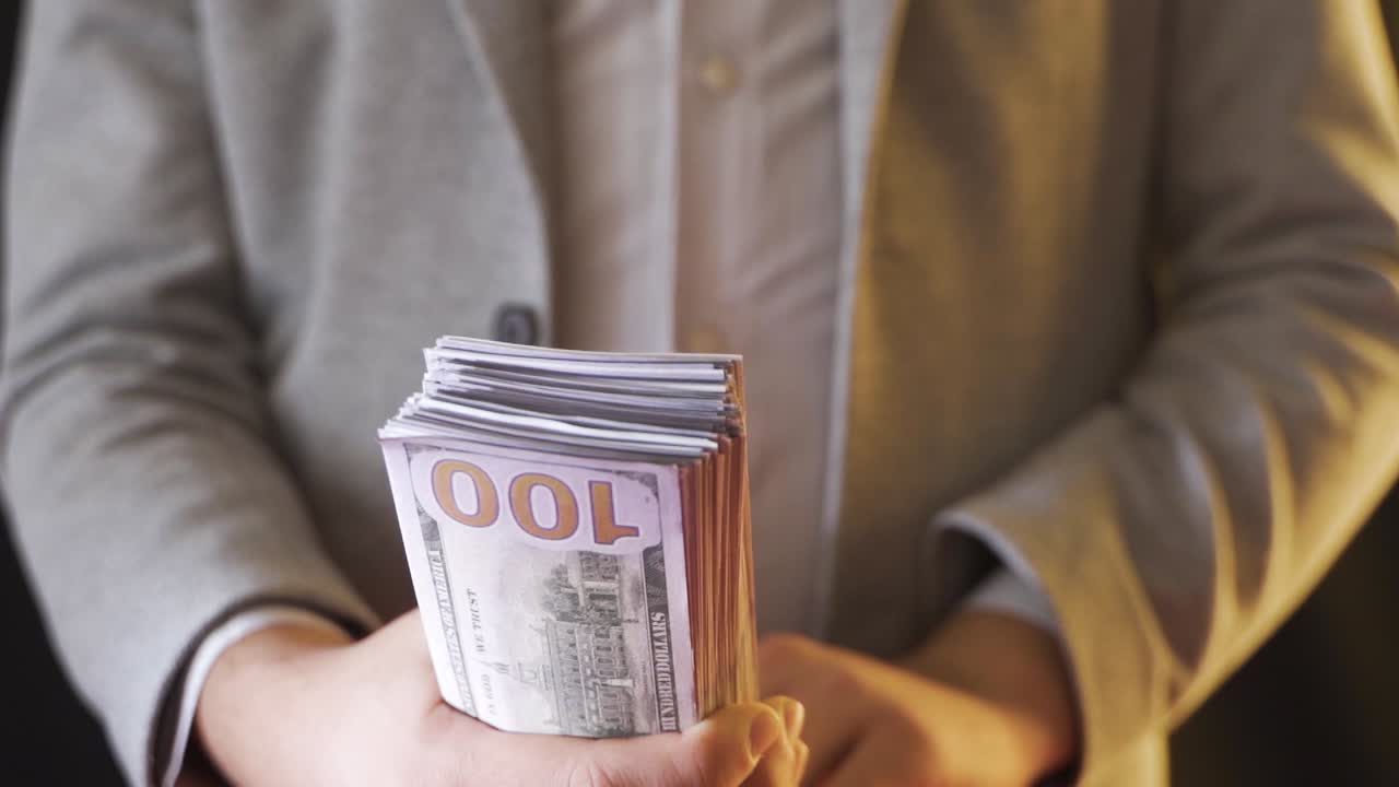 사업가가 느린 속도로 돈을 세고 있습니다.