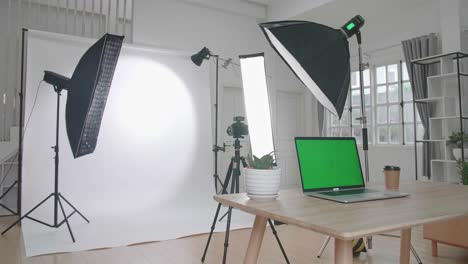 photo studio with professional equipment and green screen laptop computer display