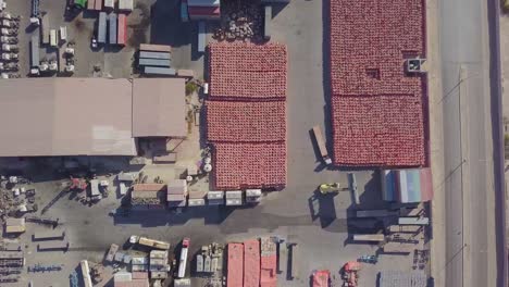 a container cargo carrier loads a truck with its blue cargo in a container yard