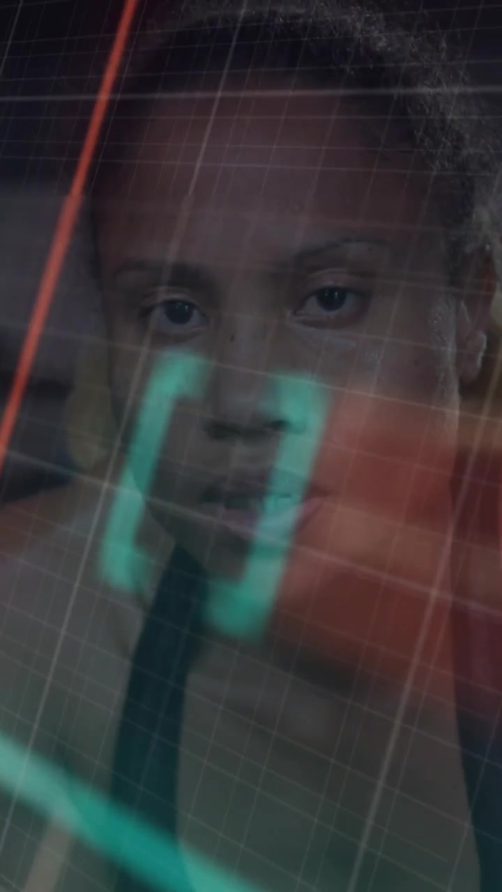 Vertical video: Woman facing teal or orange HUD sweeping and locking reticle for face-tracking tech