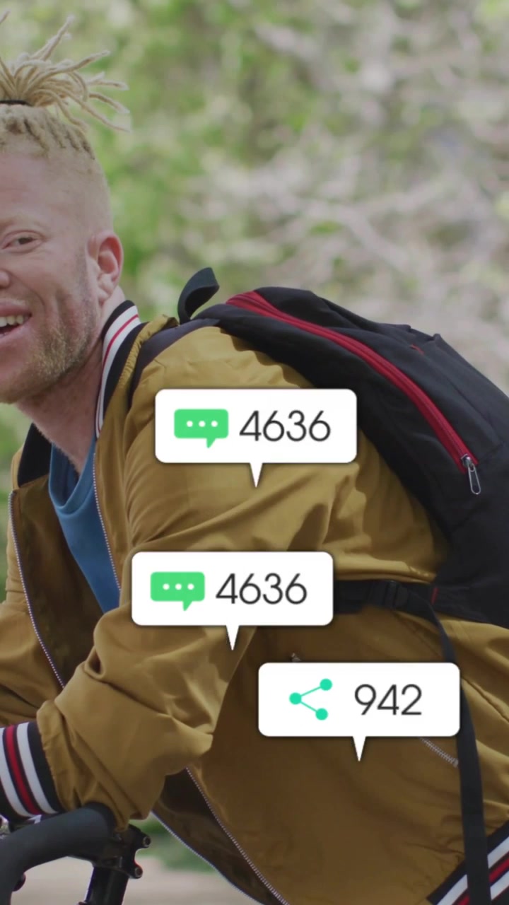 Vertical video: Cyclist on bike with icons appearing around him and growing, smiling for marketing