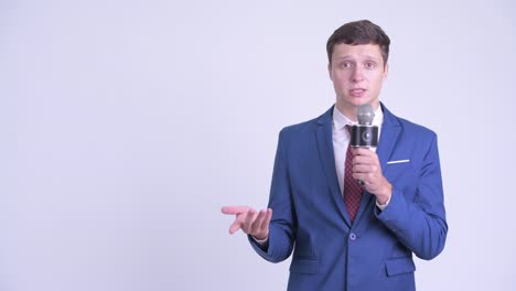 young handsome businessman in suit with microphone