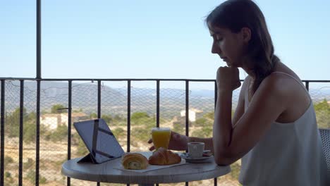 hard working woman eating breakfast and continues working on her ipad