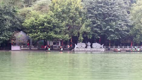 boats row past a riverside temple in vietnam