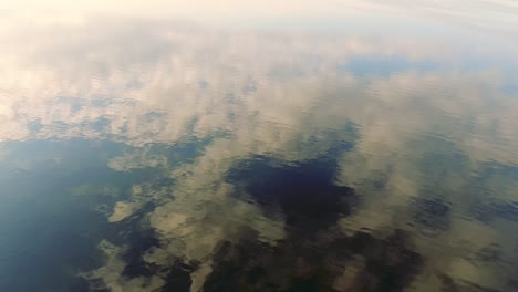 salt lake reflecting sun and clouds, symmetry aesthetic aerial landscape upward tilt up movement, sunny weather, pretty cloud, shot in salton sea