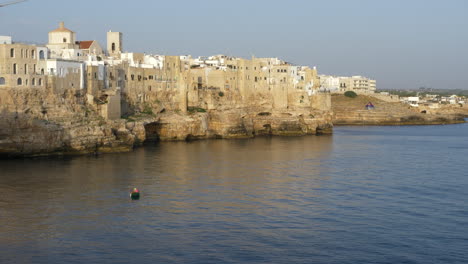 Dramatic-scene-from-Polignano-a-Mare,-golden-hour,-lone-boatman-Static