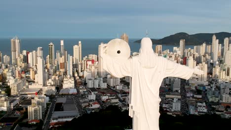 panel de vista aérea a la derecha de cristo el remeeder en balneario camboriu, brasil con la ciudad y la playa en el fondo