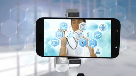 Digitally-generated-video-of-white-robotic-arm-holding-mobile-phone-that-show-medical-icons-on-scree