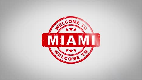 bienvenido a miami firmado texto de estampado animación de sello de madera. tinta roja en papel blanco limpio fondo de superficie con fondo matte verde incluido.