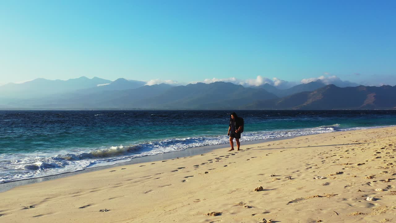 mujer turista con mochila que viene de vacaciones y camina por una playa exótica impresionada por el mar azul en bali