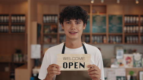 Man holding open sign in cafe