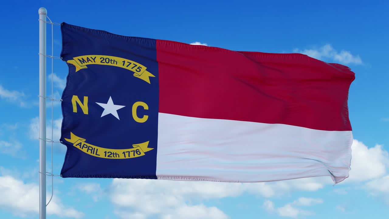 North Carolina flag on a flagpole waving in the wind, blue sky background. 4K