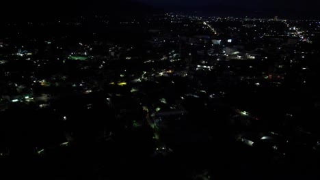 aerial overview of small town village at night, car headlights drive down street