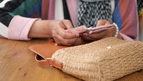 woman taking money out of bag