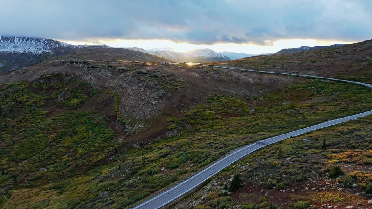 해가 지는 동안 휘어지는 산길 의 공중 사진