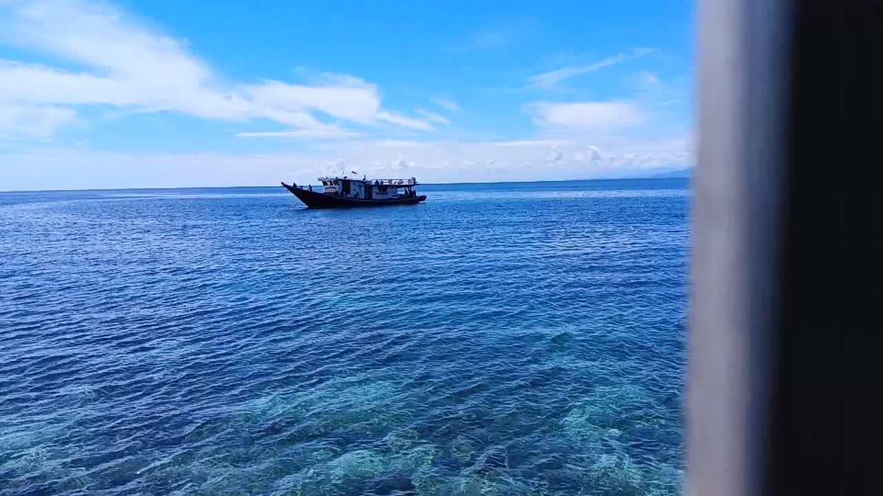 Pan shot of Boats floating on the ocean on Karampuang Island, Mamuju, West Sulawesi, Indonesia