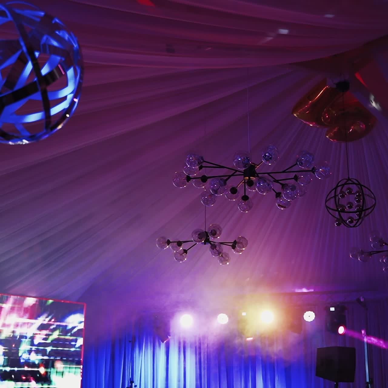 Night ceiling with balls and lights. Colorful sphere with lights shimmering in the nightclub. Lasers spotlights over concert hall.