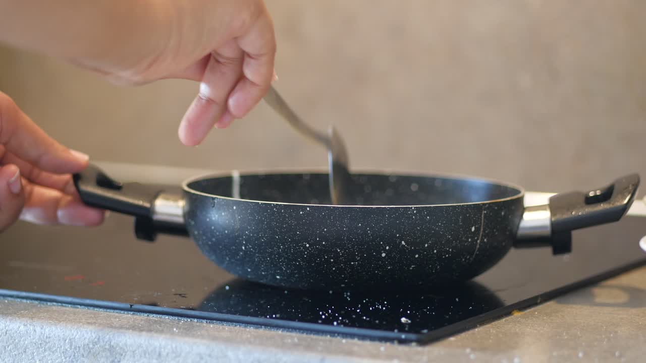 A black frying pan on an induction stovetop