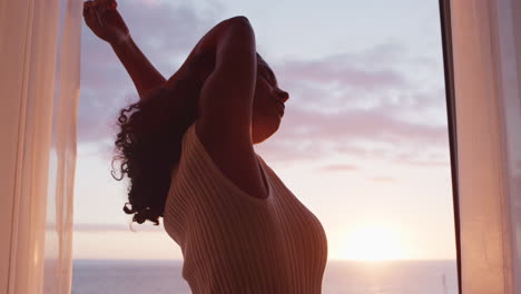 Mujer-Feliz-Con-Los-Brazos-Levantados-Disfrutando-Del-Amanecer-Temprano-En-Casa-Sintiendo-Libertad-Pacífica-Relajándose-De-Vacaciones-Mirando-La-Hermosa-Vista-Al-Mar