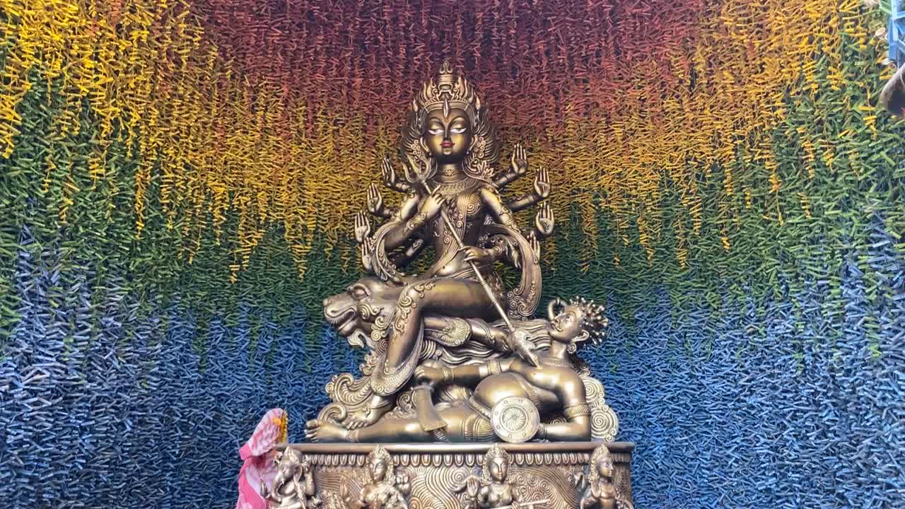la cámara se mueve hacia atrás para tomar una foto desde el primer plano hasta la figura completa de un ídolo de durga metálico